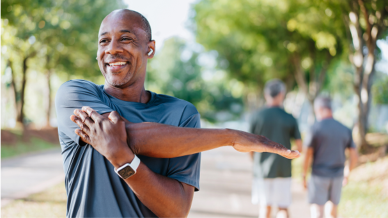 Person stretching arm outdoors.