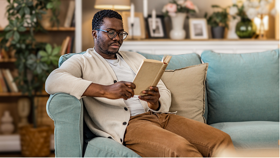 Person reading on a sofa.
